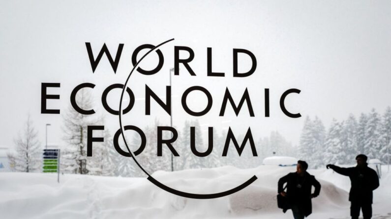 Un guardia de seguridad muestra el camino a un hombre fuera del Centro de Congresos de Davos bajo la nieve antes de la apertura de la reunión anual del Foro Económico Mundial (WEF) 2018, el 22 de enero de 2018 en Davos, este de Suiza. (FABRICE COFFRINI/AFP via Getty Images)