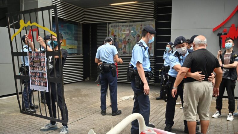 Un manifestante (a la derecha) es registrado por la policía mientras en Hong Kong comienza la selección de un poderoso comité bajo un nuevo sistema "solo para patriotas" impuesto por Beijing, en Hong Kong, el 19 de septiembre de 2021. (Peter Parks/AFP vía Getty Images)