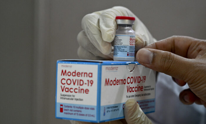 Un trabajador sanitario comprueba una caja de la vacuna de Moderna contra la COVID-19 donada por Estados Unidos durante una campaña de vacunación de refuerzo en el hospital Zainoel Abidin de Banda Aceh (Indonesia) el 9 de agosto de 2021. (Chaideer Mahyuddin/AFP vía Getty Images)