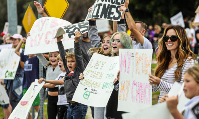 Los manifestantes protestan fuera de la oficina del Distrito Escolar Unificado de San Diego contra la orden de vacunación para los estudiantes en San Diego, California, el 28 de septiembre de 2021. (Sandy Huffaker/Getty Images)
