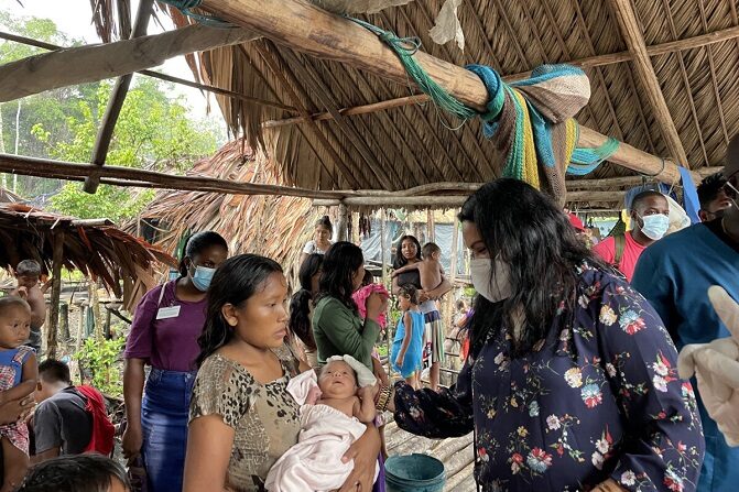 La ministra de Seguridad Humana y Social de Guyana, Dra. Vindhya Persaud, interactuando con la madre y el bebé Warao. (Richard Bhainie/The Epoch Times)
