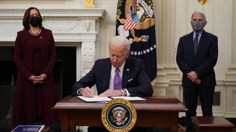 El presidente Joe Biden firma órdenes ejecutivas como parte de la respuesta al COVID-19 mientras la vicepresidenta Kamala Harris (izquierda) y el director del NIAID Anthony Fauci observan en el Comedor de Estado de la Casa Blanca, en Washington, el 21 de enero de 2021. (Mandel Ngan/AFP vía Getty Images)