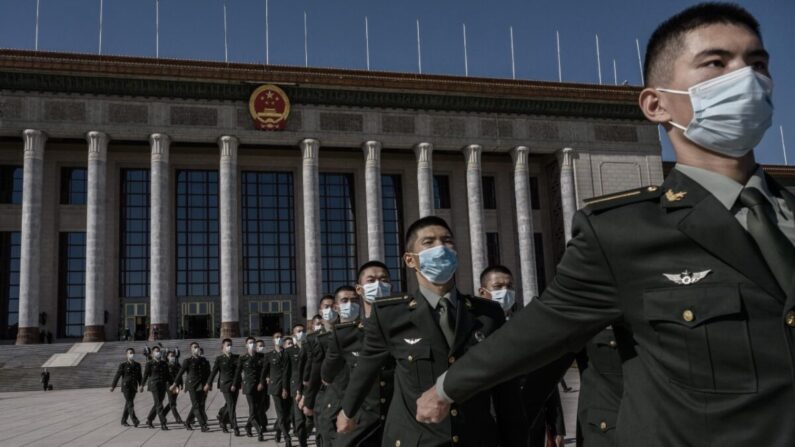 Soldados chinos del Ejército Popular de Liberación llevan mascarillas mientras marchan después de una ceremonia que marca el 70 aniversario de la entrada de China en la Guerra de Corea, el 23 de octubre de 2020 en el Gran Salón del Pueblo en Beijing, China. (Kevin Frayer/Getty Images)