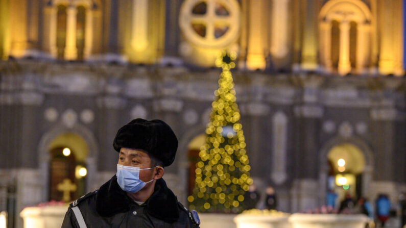 Un guardia de seguridad con una mascarilla hace guardia en la Iglesia de San José durante una misa en la víspera de Navidad en Beijing el 24 de diciembre de 2020. (Noel Cells/AFP vía Getty Images)