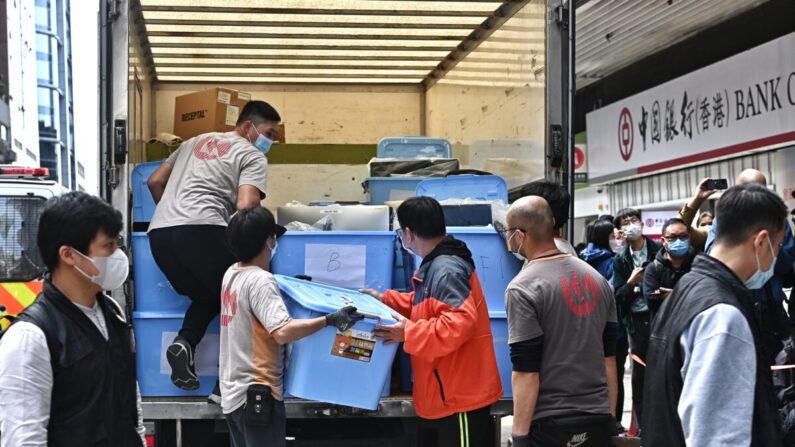 Unos trabajadores transportan unos contenedores fuera de la oficina de Stand News en Hong Kong el 29 de diciembre de 2021. (Sung Pilung/The Epoch Times)