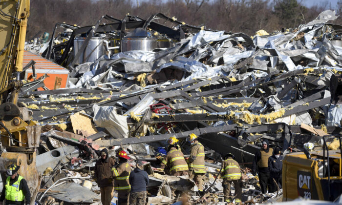 Trabajadores de emergencia buscan entre lo que queda de la fábrica de velas Mayfield Consumer Producers, en Mayfield, Kentucky, el 11 de diciembre de 2021. (John Amis/AFP vía Getty Images)