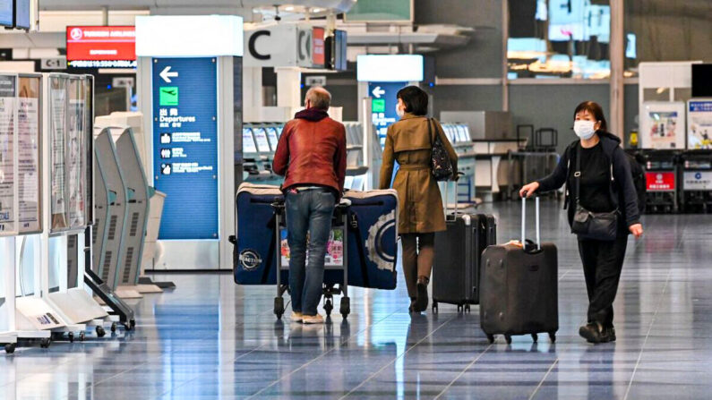 Viajeros pasando por los mostradores de registro en una planta de salidas de vuelos internacionales en el aeropuerto de Haneda de Tokio, el 1 de diciembre de 2021. (Kazuhiro Nogi/AFP vía Getty Images)