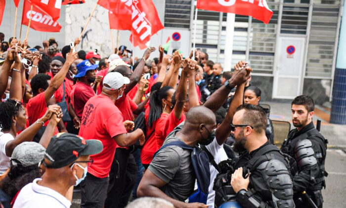 Manifestantes participan en una protesta contra la vacunación obligatoria para COVID-19 frente a la prefectura de Martinica en Fort-de-France, en la isla caribeña francesa de Martinica, el 30 de noviembre de 2021. (Alain Jocard/AFP a través de Getty Images)