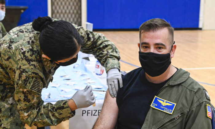 Un oficial de la Marina recibe una dosis de refuerzo de la vacuna anti-COVID durante un ejercicio de inmunización masiva en la Estación Aérea Naval de Sigonella, el 7 de diciembre de 2021. (foto de la Marina de los EE.UU./Josh Cote, especialista en comunicación de masas de segunda clase)
