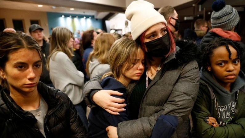 Personas se abrazan durante una vigilia después de un tiroteo en la escuela secundaria de Oxford en la iglesia comunitaria de Lake Pointe en Lake Orion, Michigan, el 30 de noviembre de 2021. - Un estudiante de 15 años abrió fuego en su escuela secundaria de Michigan el 30 de noviembre, matando a tres adolescentes e hiriendo a otras ocho personas antes de entregarse a la policía, dijeron las autoridades, en lo que fue el tiroteo escolar estadounidense más mortífero en lo que va del año. (JEFF KOWALSKY/AFP vía Getty Images)