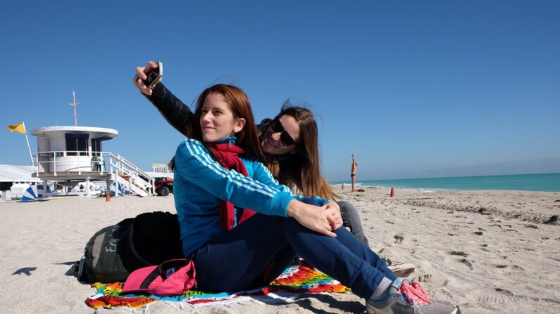 Fotografía de archivo de dos mujeres que se toman un selfie en la desierta playa de Miami Beach. EFE/GASTON DE CARDENAS
