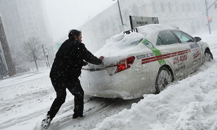 Un hombre empuja un taxi en las calles de Boston mientras cae la nieve de una gran tormenta invernal, el 4 de enero de 2018. (Spencer Platt/Getty Images)
