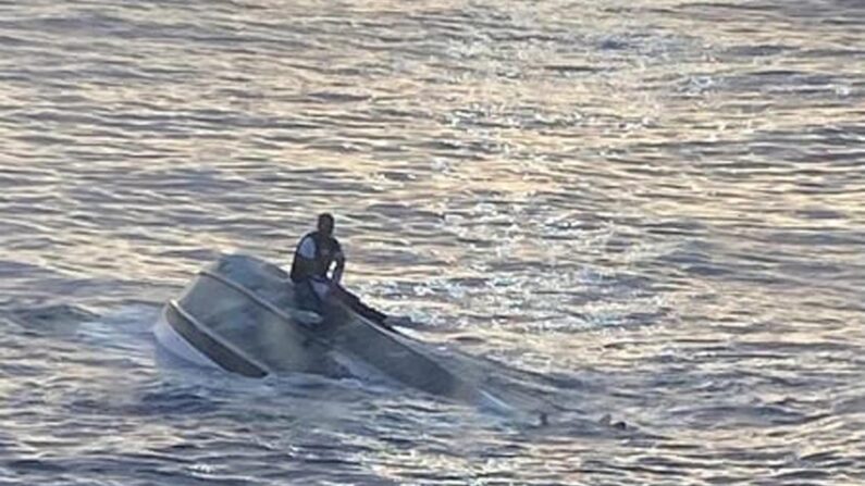 Fotografía cedida por la Guardia Costera de los Estados Unidos (USCG) que muestra a una persona en un barco volcado frente a Fort Pierce Inlet, Florida, EE.UU. EFE/EPA/US COAST GUARD/