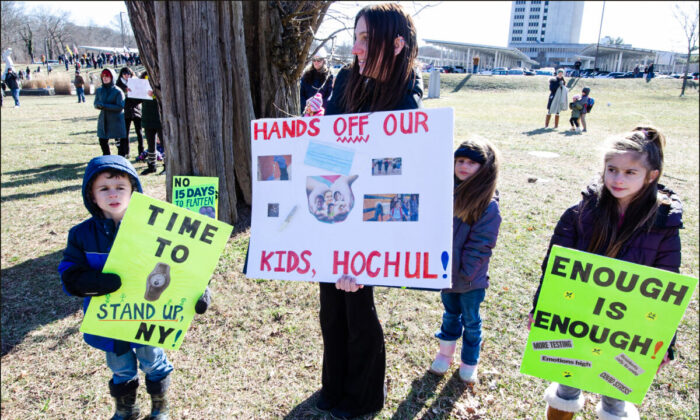 Una madre y sus hijos en una protesta de la "Long Island Loud Majority" contra las mascarillas obligadas por el estado para los escolares el 26 de enero de 2022, en las oficinas del gobierno del Condado de Suffolk. (Dave Paone/The Epoch Times)