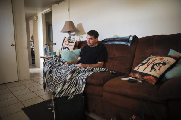 Edward Fritsch se sienta con la manta de crochet sin terminar que su madre le estaba haciendo antes de morir a causa de un choque con un traficante de personas que huía de las autoridades, en Arizona, el 9 de diciembre de 2021. (Charlotte Cuthbertson/The Epoch Times)
