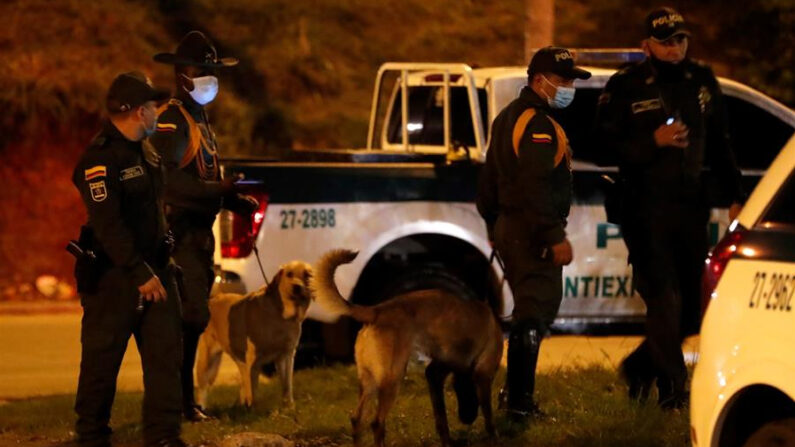Agentes vigilan este sábado 8 de enero de 2022 con perros entrenados en búsqueda de explosivos la zona del atentado contra un camión de la Policía Nacional colombiana en Cali (Colombia). EFE/ Ernesto Guzmán Jr