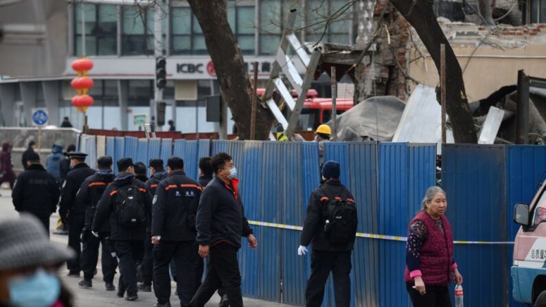 En una foto de archivo, investigadores y residentes caminan fuera de los restos de un restaurante que fue cercado después de que fue destruido en una explosión, cerca del complejo de liderazgo Zhongnanhai en Beijing el 23 de febrero de 2021. (Greg Baker/AFP vía Getty Images)