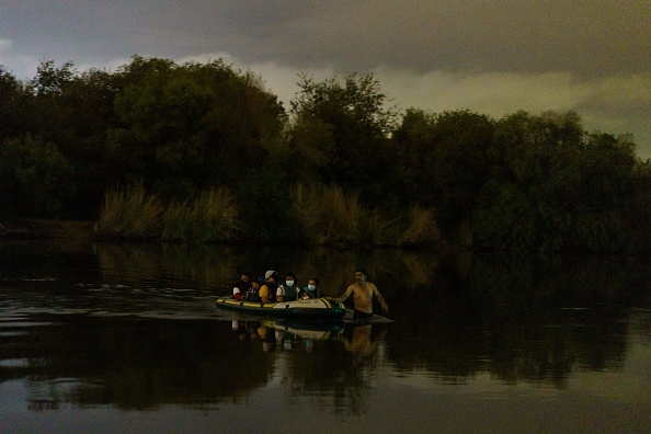 Un traficante de personas jala una balsa inflable para cruzar el Río Grande y entrar en Estados Unidos entre Miguel Alemán, Tamaulipas, México y Roma, Texas, el 7 de julio de 2021. (PAUL RATJE/AFP vía Getty Images)