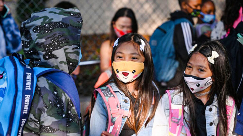 Estudiantes y padres llegan usando mascarillas para el primer día del año escolar en la escuela primaria Grant en Los Ángeles, el 16 de agosto de 2021. (Robyn Beck/AFP vía Getty Images)