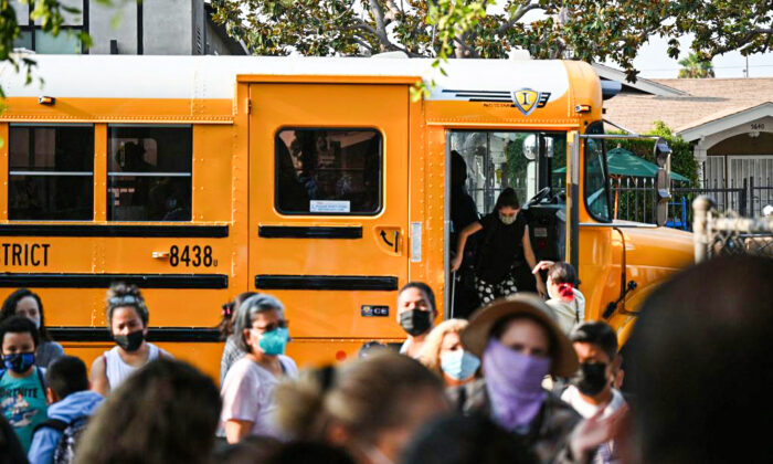 Estudiantes y padres llegan con mascarillas el primer día del año escolar a la Escuela Primaria Grant, en Los Ángeles, el 16 de agosto de 2021. (Robyn Beck/AFP a través de Getty Images)