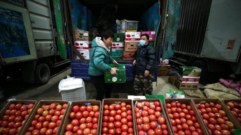 Vendedores de tomates esperan a los clientes en un mercado de Shenyang, en la provincia nororiental china de Liaoning, el 9 de diciembre de 2021. (STR/AFP vía Getty Images)