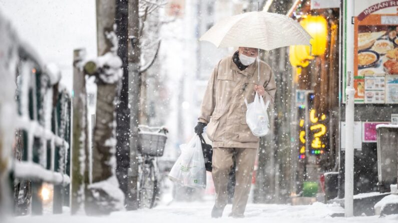 Un hombre camina por una calle mientras nieva en Tokio (Japón) el 6 de enero de 2022. (Philip Fong/AFP vía Getty Images)