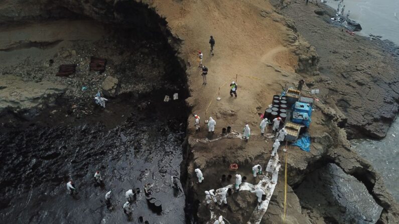 Vista aérea de cuadrillas de limpieza trabajando para retirar el petróleo de una playa anexa al balneario de Ancón, en el norte de Lima, el 22 de enero de 2022. (CARLOS REYES/AFP vía Getty Images)

