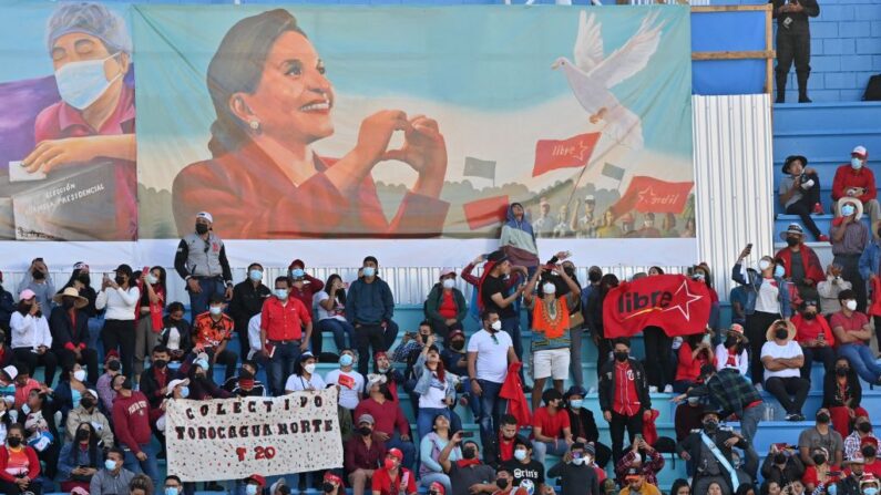 Simpatizantes de la presidenta de Honduras, Xiomara Castro, esperan el inicio de su ceremonia de investidura, junto a un cartel que la representa, en Tegucigalpa, el 27 de enero de 2022.  (LUIS ACOSTA/AFP vía Getty Images)
