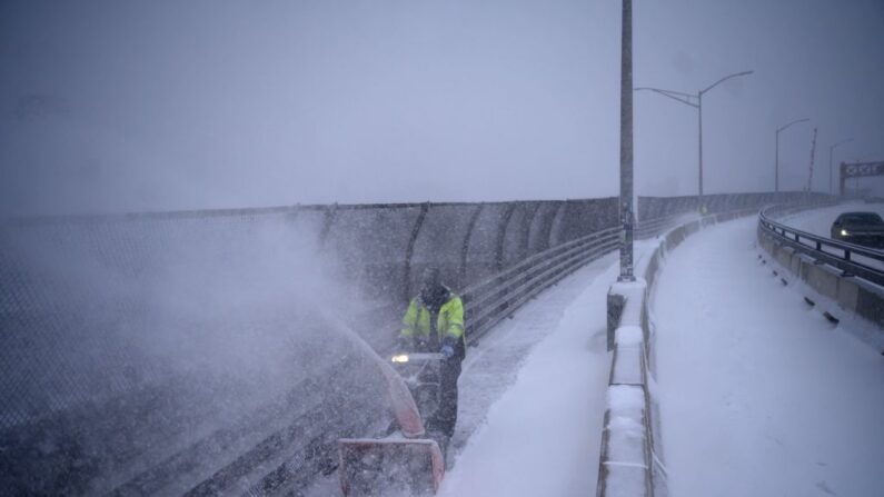 Un trabajador quita la nieve en un puente en el barrio neoyorquino de Brooklyn el 29 de enero de 2022. (ED JONES/AFP vía Getty Images)