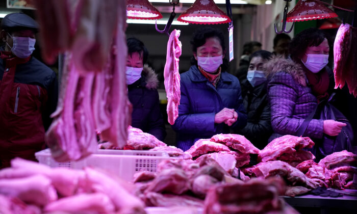 Los residentes de Wuhan, provincia de Hubei, China, compran carne de cerdo para hacer salchichas para el próximo Festival de Primavera chino en una calle famosa por sus salchichas, el 31 de diciembre de 2020. (Getty Images)