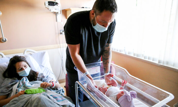 Matthew Carnes se prepara para cambiar los pañales de su hija recién nacida, Evelina Carnes, mientras su esposa, Breanna Llamas, está en la unidad de posparto, en el Centro Médico Providence St. Mary, en Apple Valley, California, el 30 de marzo de 2021. (Mario Tama/Getty Images)
