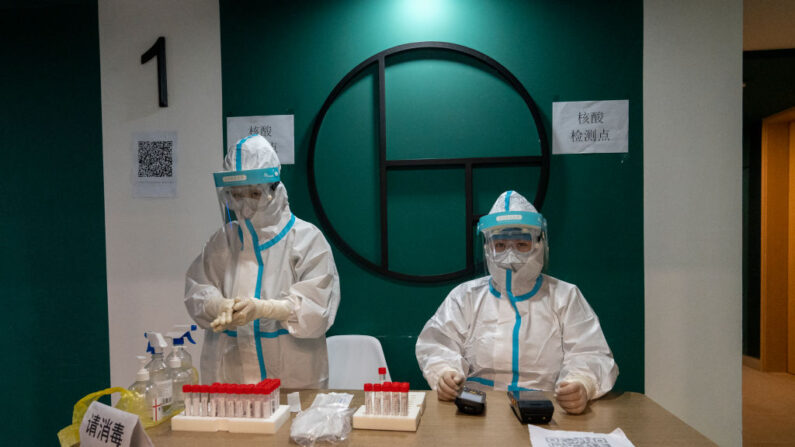 Trabajadores médicos con EPI se preparan para hacer pruebas de PCR a los trabajadores de los medios de comunicación en el Hotel Prince Ski Town el 05 de diciembre de 2021 en Taizicheng, Zhangjiakou, China. (Andrea Verdelli/Getty Images)