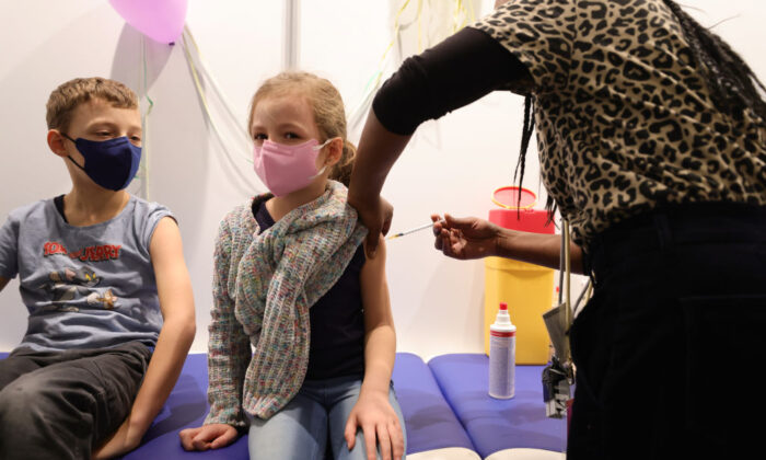 Los niños reciben una dosis de la vacuna COVID-19 Pfizer-BioNTech Comirnaty para niños en la sección infantil del centro de vacunación Lanxess Arena en Colonia, Alemania, el 18 de diciembre de 2021. (Andreas Rentz/Getty Images)