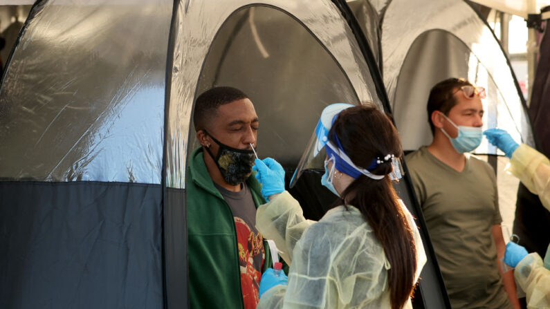 Eddie Lewis (izq.) e Irving Gutiérrez se someten a las pruebas de COVID-19 realizadas por los trabajadores de la salud el 13 de enero de 2022 en North Miami, Florida. (Joe Raedle/Getty Images)
