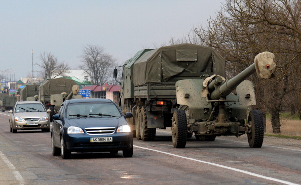 Camiones militares sin identificar pertenecientes a las fuerzas rusas remolcan cañones mientras se desplazan en convoy hacia la zona fronteriza entre Crimea y la región ucraniana de Kherson, en la carretera cerca de la ciudad de Dzhankoy, el 14 de marzo de 2014. (VASILY MAXIMOV/AFP a través de Getty Images)