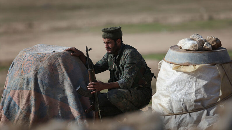 Un soldado de las Fuerzas Democráticas Sirias se pone a cubierto en la línea del frente contra ISIS el 11 de noviembre de 2015 cerca de Hasaka, en la región autónoma de Rojava, Siria. (John Moore/Getty Images)
