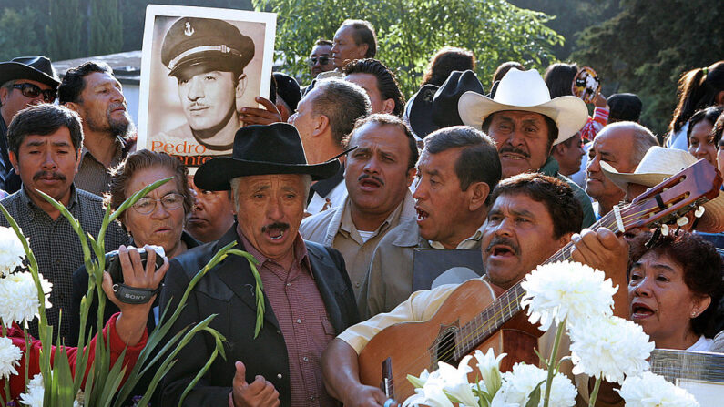 Ciudad de México, MÉXICO: Una fan sostiene una foto del fallecido actor y cantante mexicano Pedro Infante, frente a su tumba durante la conmemoración del 50 aniversario de su muerte en el cementerio El Jardín, en Ciudad de México, el 15 de abril de 2007. (LUIS ACOSTA/AFP via Getty Images)
