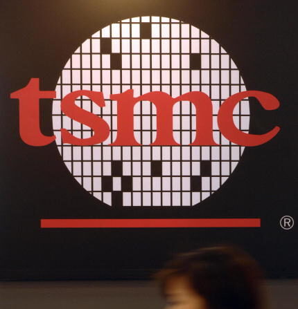 Una mujer pasa junto a un logotipo de TSMC, Taiwan Semiconductor Manufacturing Co, el mayor fabricante de chips a medida del mundo, durante la feria de semitecnología de Taipei, el 10 de mayo de 2007. (SAM YEH/AFP a través de Getty Images)