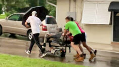 4 jóvenes ayudan a una anciana con su silla eléctrica averiada en medio de una tormenta