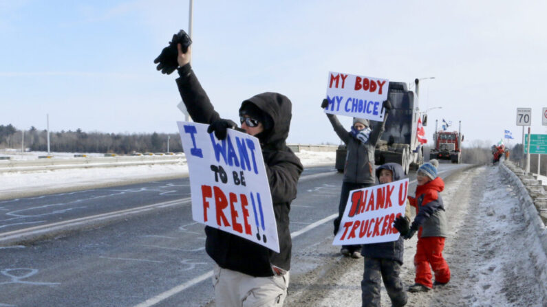 Los partidarios de "Freedom Convoy" saludan a los camiones que pasan por el sur de Montreal el 28 de enero de 2022. (Noé Chartier/The Epoch Times)