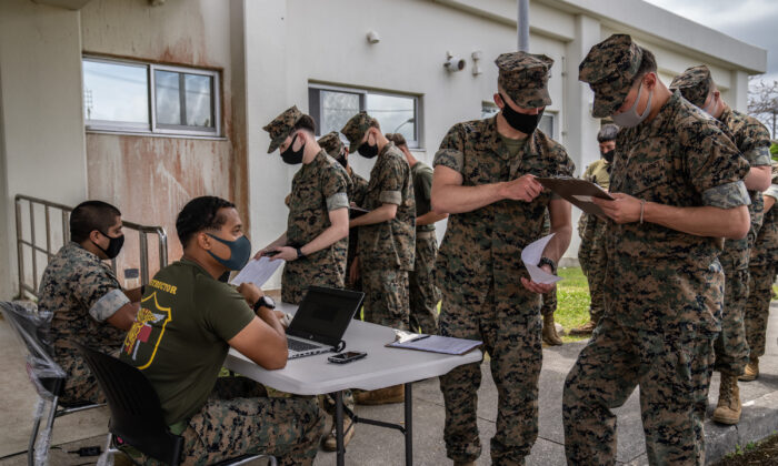 Marines de Estados Unidos registran sus datos mientras hacen cola para recibir la vacuna Moderna COVID-19 en Camp Hansen el 28 de abril de 2021 en Kin, Japón. (Carl Court/Getty Images)