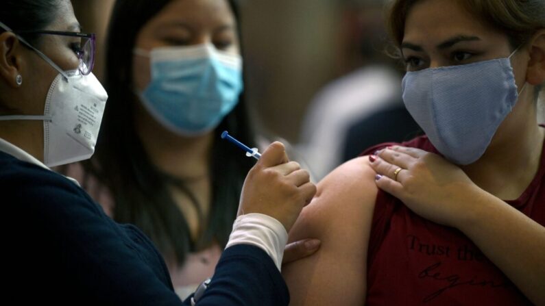 Una joven recibe una primera dosis de la vacuna de AstraZeneca contra la COVID-19 en la Ciudad de México, el 10 de agosto de 2021. (Alfredo Estrella/AFP vía Getty Images)