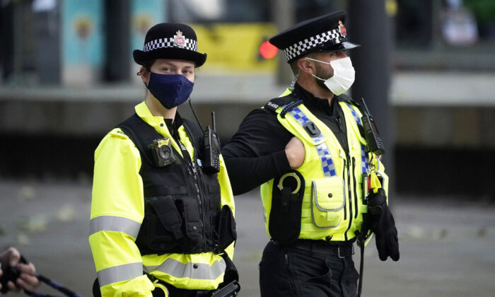 Agentes de policía llevan mascarillas mientras patrullan el centro de la ciudad en Manchester, Inglaterra, el 20 de octubre de 2020. (Christopher Furlong/Getty Images)