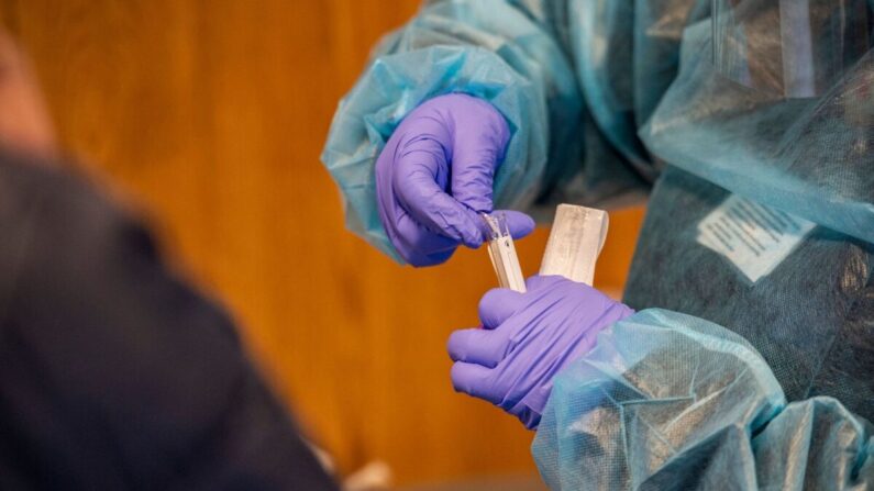 Un trabajador médico coloca un hisopo nasal en un tubo de ensayo luego de realizar una prueba PCR de COVID-19 en el East Boston Neighborhood Health Center en Boston, Massachusetts, el 20 de diciembre de 2021. (Joseph Prezioso/AFP vía Getty Images)