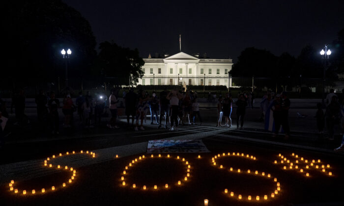 Unos manifestantes usan velas frente a la Casa Blanca el 18 de julio de 2021 para deletrear SOS en solidaridad con las protestas en Cuba. (Stefani Reynolds/Getty Images)
