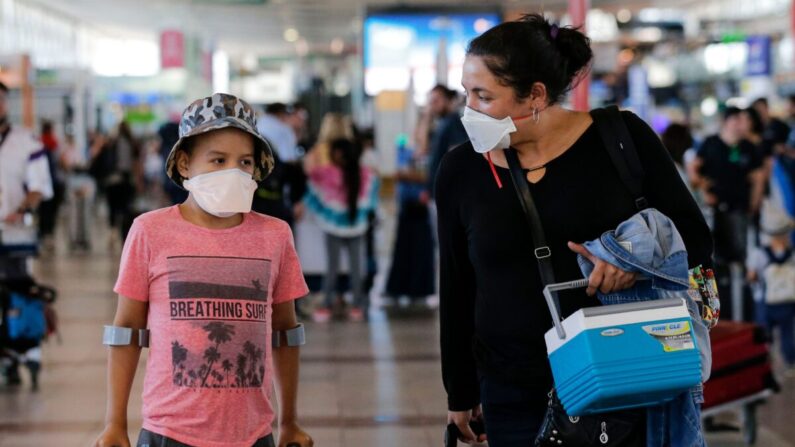 Pasajeros caminan con mascarillas en el Aeropuerto Internacional Arturo Merino Benítez en Santiago, Chile, el 3 de marzo de 2020. (Javier Torres/AFP vía Getty Images)