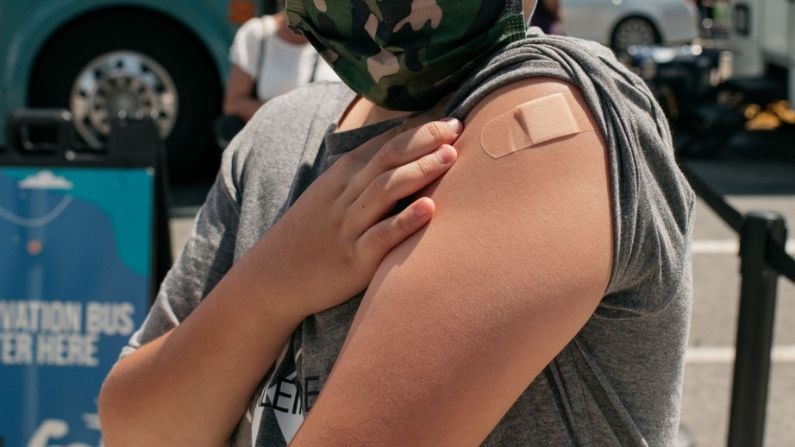 Un niño de 13 años recién vacunado contra COVID-19 muestra su vendaje en un centro de vacunación emergente el 5 de junio de 2021 en el barrio de Jackson Heights, en el distrito de Queens, en la ciudad de Nueva York. Con la vacuna de Pfizer aprobada para niños a partir de 12 años, la elegibilidad de la vacuna se ha ampliado a los adolescentes y preadolescentes en los 50 estados. (Scott Heins/Getty Images)