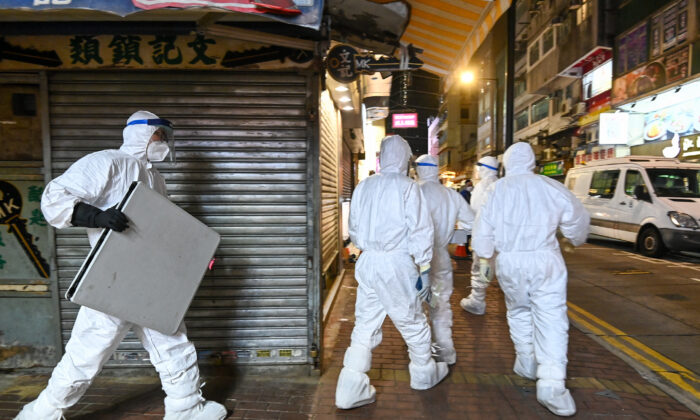 Funcionarios de salud de Hong Kong ingresan a una tienda de mascotas para sacrificar animales y desinfectar la tienda, en Causeway Bay, el 18 de enero de 2022. (Sung Pilung/The Epoch Times)
