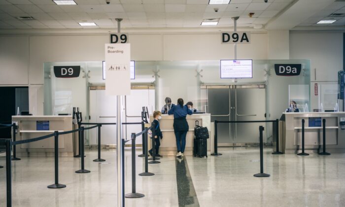 Una mujer y su hijo hablan con un asistente de la aerolínea en el Aeropuerto Intercontinental George Bush en Houston, Texas, en medio de cancelaciones y retrasos de vuelos, el 6 de enero de 2022. (Brandon Bell/Getty Images)