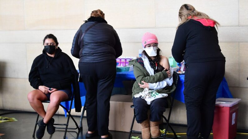 Unas personas reciben la vacuna COVID-19 en la estación Union Station de Los Ángeles, California, el 7 de enero de 2022. (Frederic J. Brown/AFP vía Getty Images)